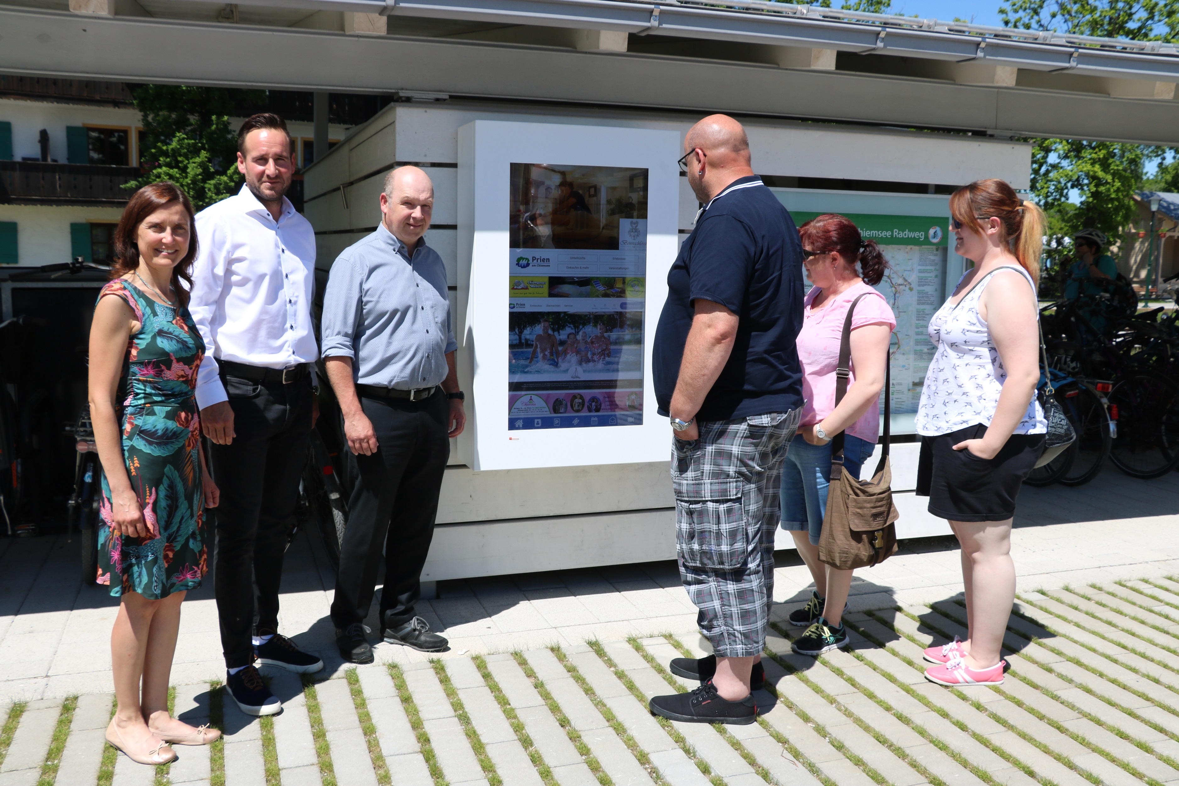Bei Urlaubern ist der neue Gäste-Infoterminal am Hafen Prien/Stock, Visasvis von dem Bürogebäude der Chiemsee-Schifffahrt, bereits gut angenommen: (v.l.n.r.) Ein Fazit, welches die Geschäftsführerin der Prien Marketing GmbH Andrea Hübner und der Leiter des Tourismusbüros Florian Tatzel bei ihrer Besichtigung am Montag, 3. Juni 2019 zogen. Zu den Touristikern gesellte sich der Junior-Geschäftsführer der Chiemsee-Schifffahrt Ludwig Feßler KG Michael Feßler, der sein Gelände für die Montage zur Verfügung stellte. (Foto: Prien Marketing GmbH)