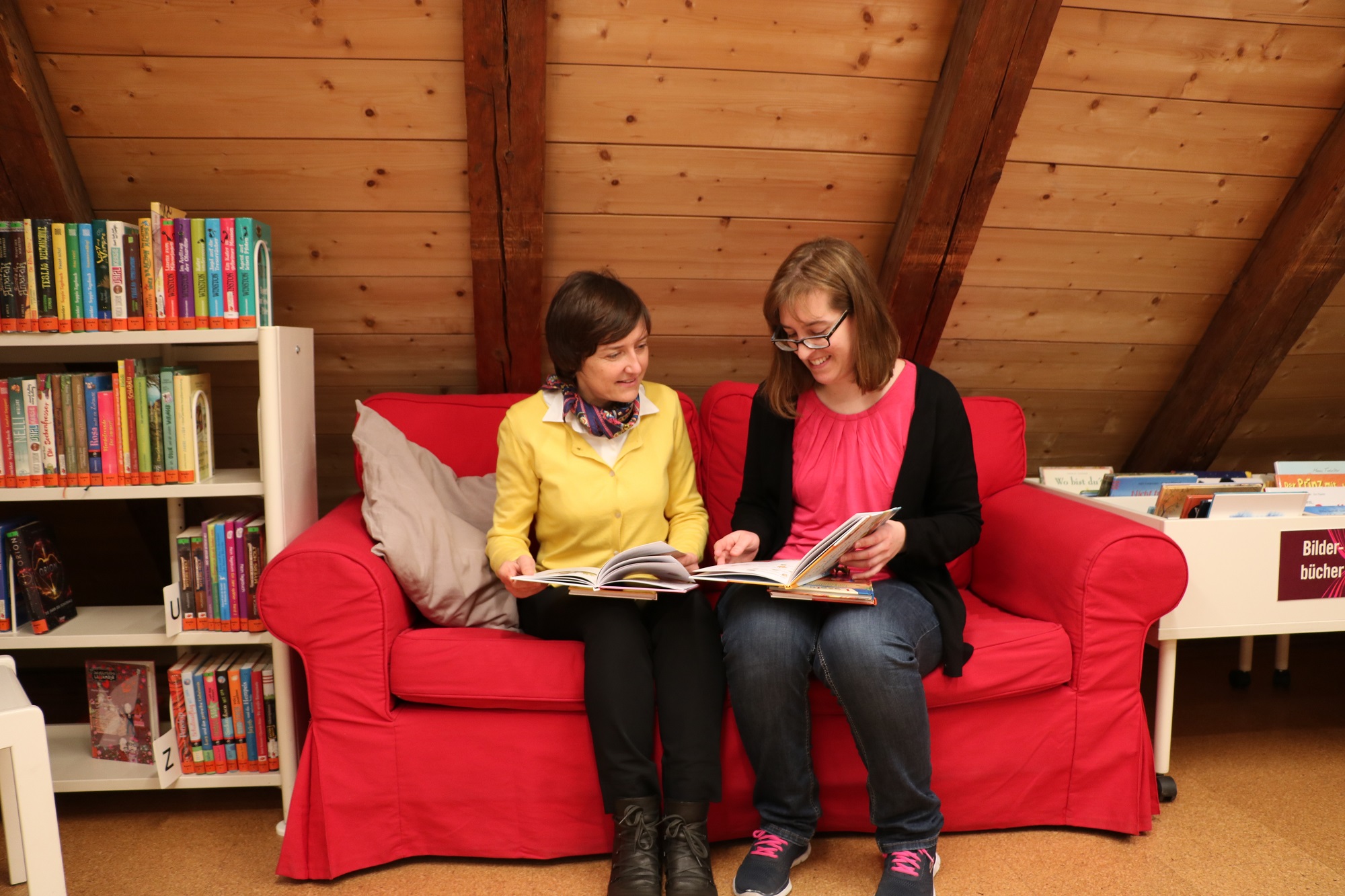(v.l.n.r.) Die Geschäftsführerin der Prien Marketing GmbH Andrea Hübner begrüßte die neue Kollegin Christina Klasna im Dachgeschoss des Haus des Gastes. Gemeinsam werfen sie einen Blick auf die vielen neuen Titel zum Lesestart in der Kinderabteilung.